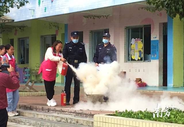 公安民警變身“消防安全老師”，指導(dǎo)幼兒園老師使用滅火器。