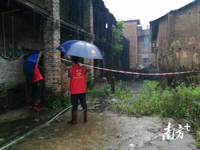 黨群志愿者冒雨拉起警戒線。